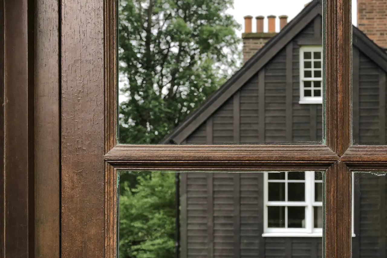 Close-up of a slim timber sash window with heritage glazing bars and horns