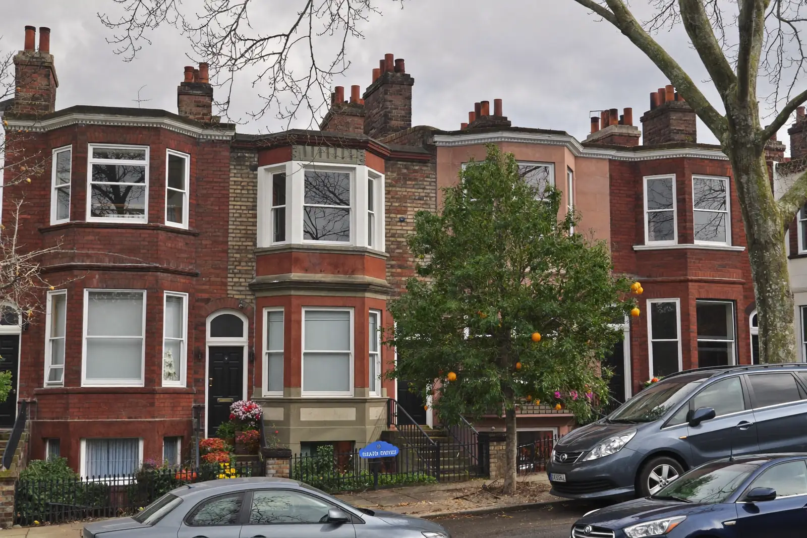 Street of UK terraced houses with a mix of old and new windows